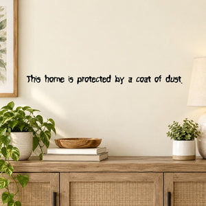 Wall decal with script text: 'This home is protected by a coat of dust.'