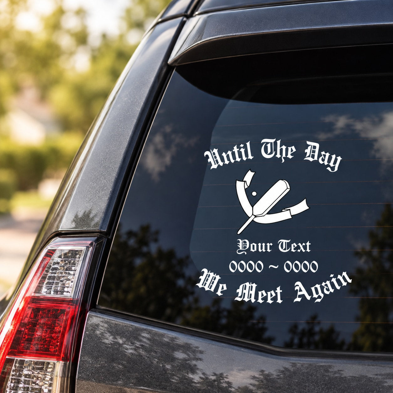 Memorial car window decal with white text and ribbon cross on dark glass