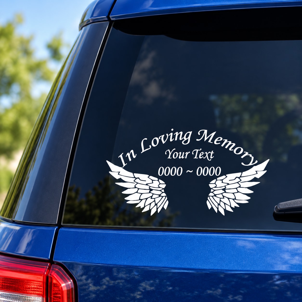 White memorial lettering sticker with wings graphic and custom text on dark window