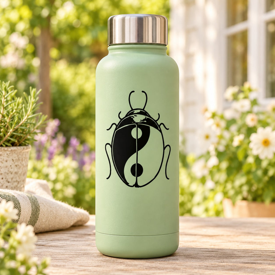 Yin-yang ladybug decal on a mint green water bottle with silver cap