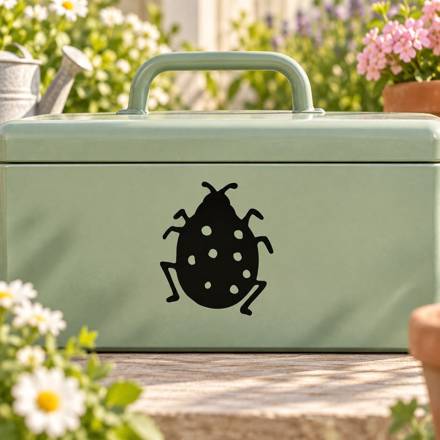 Black ladybug decal with white dot pattern on green surface