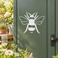 White bumble bee line-art decal on a dark green surface