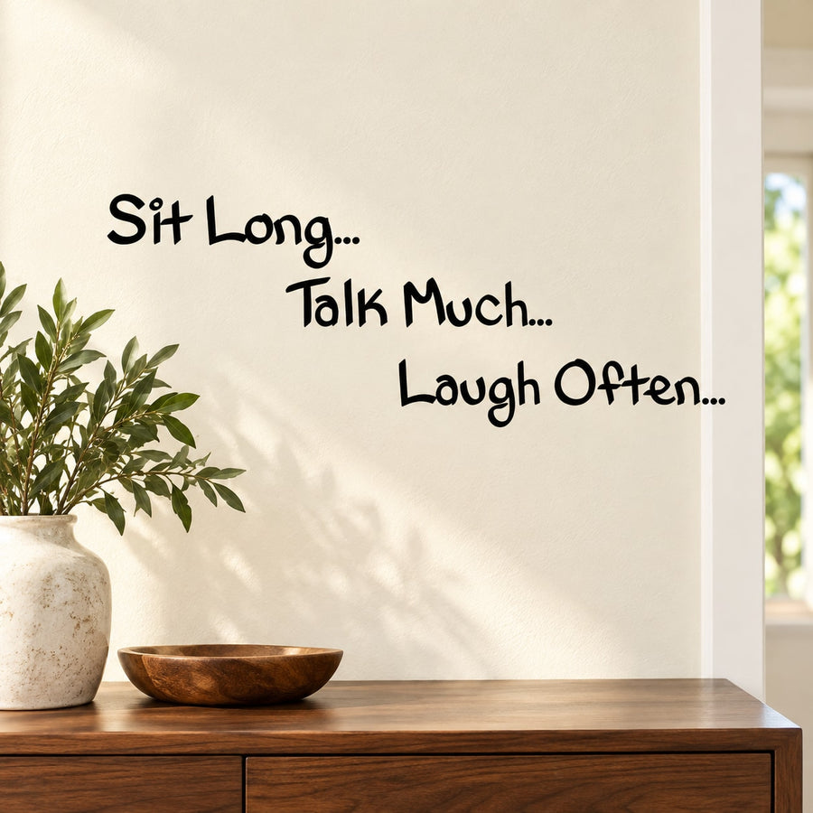 Wall decal with text: “Sit Long… Talk Much… Laugh Often…” in black lettering