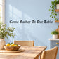 Wall decal with "Come Gather At Our Table" black lettering