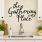 Cursive wall decal text "The Gathering Place" in black