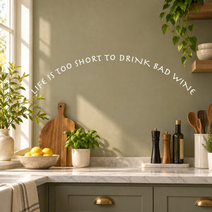 Wall decal with curved quote text: “Life is too short to drink bad wine”