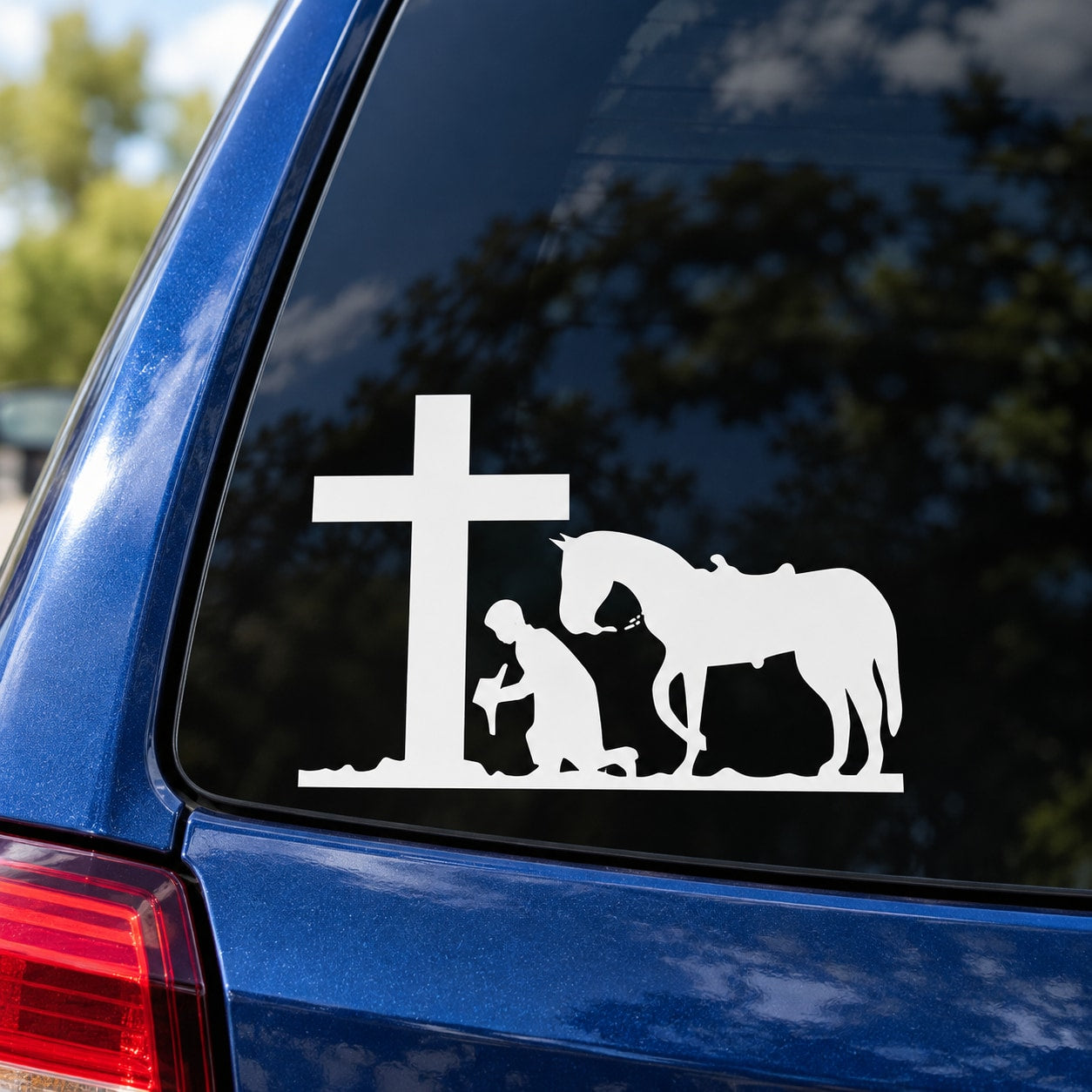White vehicle decal with cross, praying cowboy silhouette, and horse