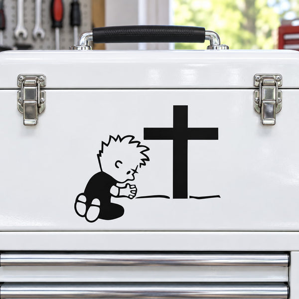 Praying Calvin decal with black cross on white surface