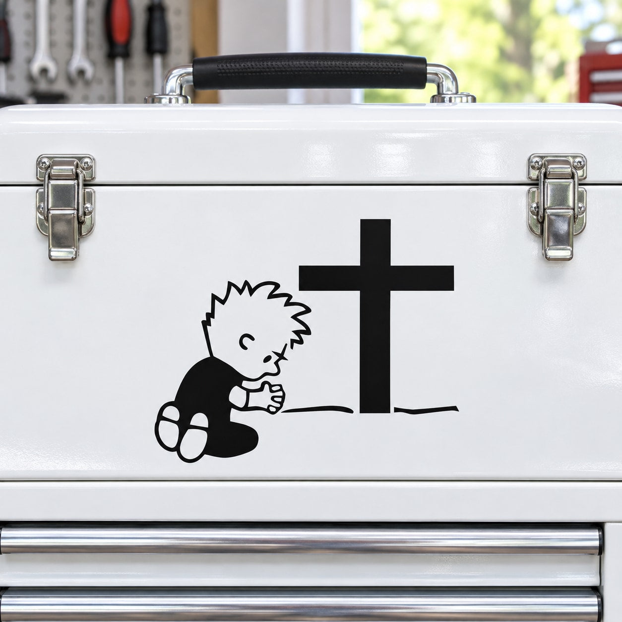 Praying Calvin decal with black cross on white surface