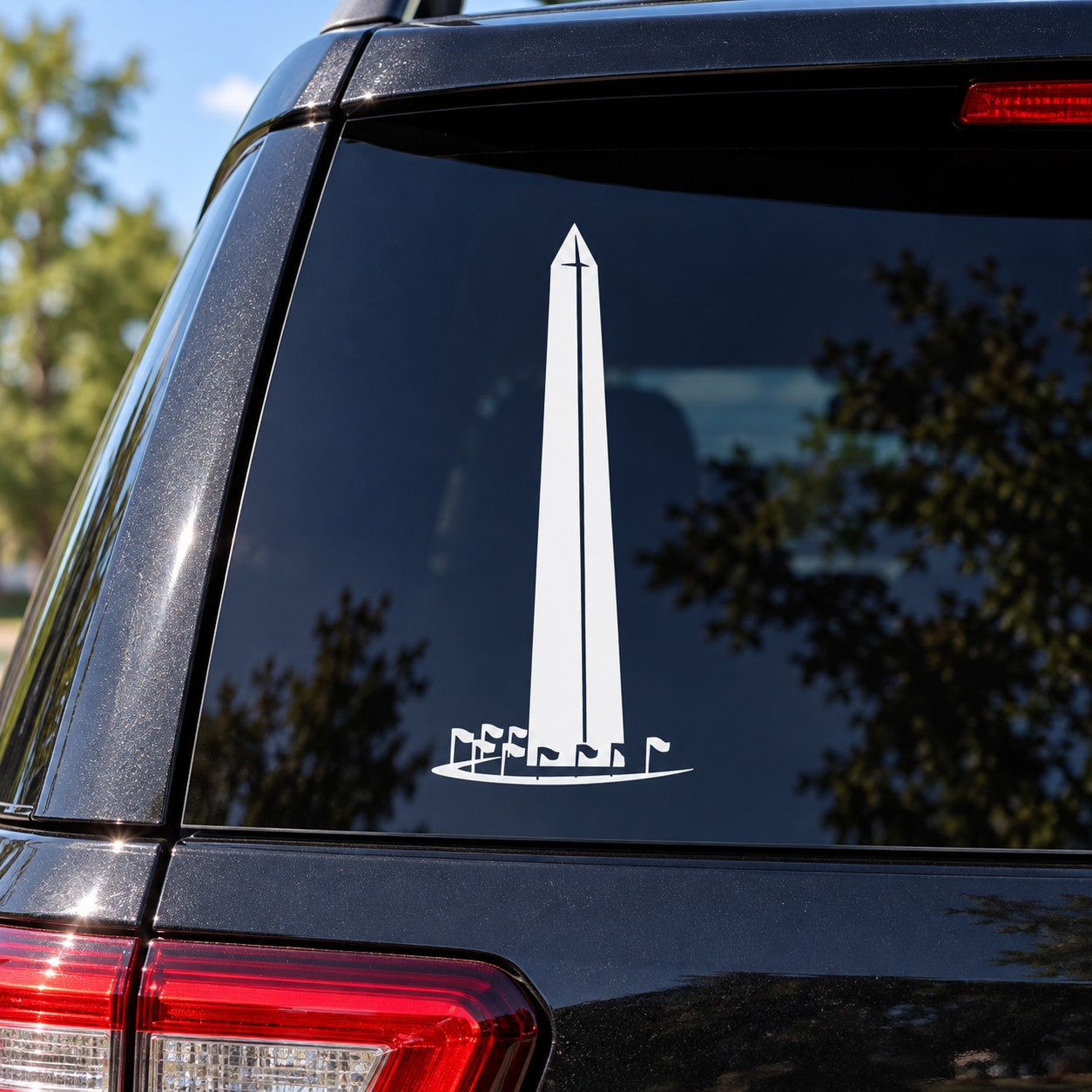 Car window decal with white Washington Monument and small flags