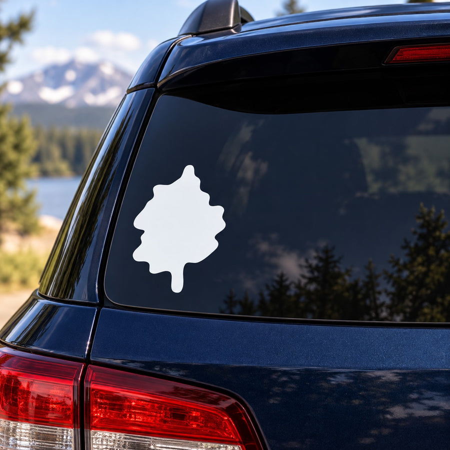 White vinyl landscape decal with tree-shaped silhouette on a car rear window