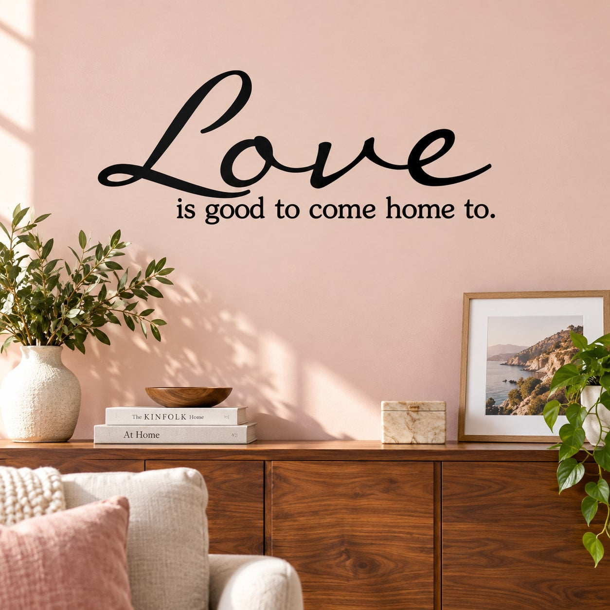 Black wall decal with "Love is good to come home to." lettering