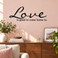 Black wall decal with "Love is good to come home to." lettering