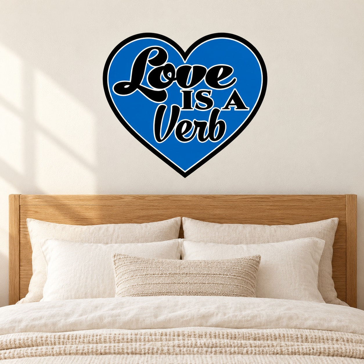 Blue heart-shaped sticker with white “Love is a Verb” lettering