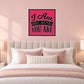 Square pink wall sticker with black border and 'I Am Because You Are' lettering
