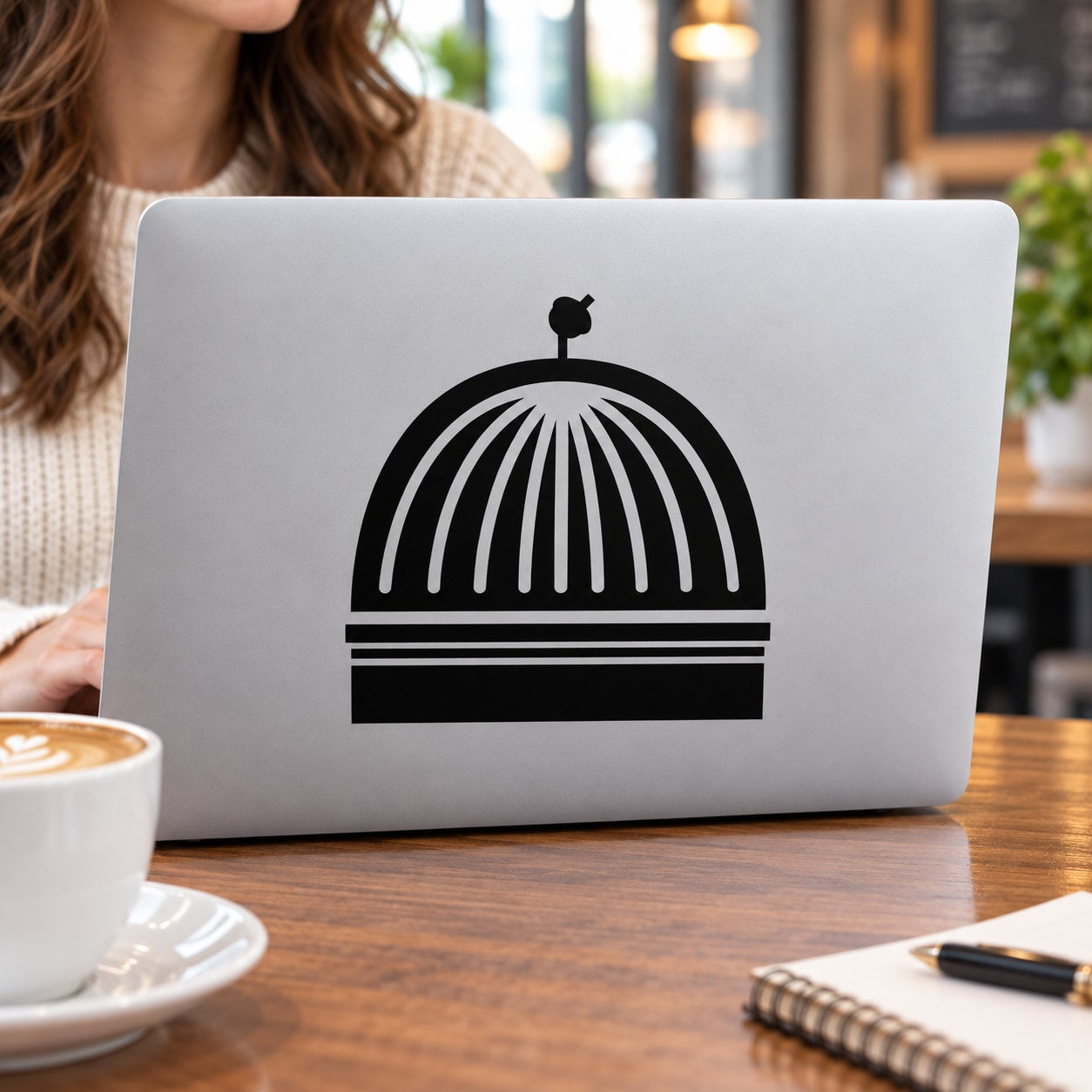 Black-and-white dome icon decal on a white laptop lid