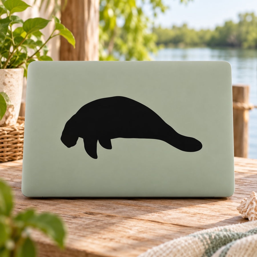 Black manatee decal on light green laptop cover