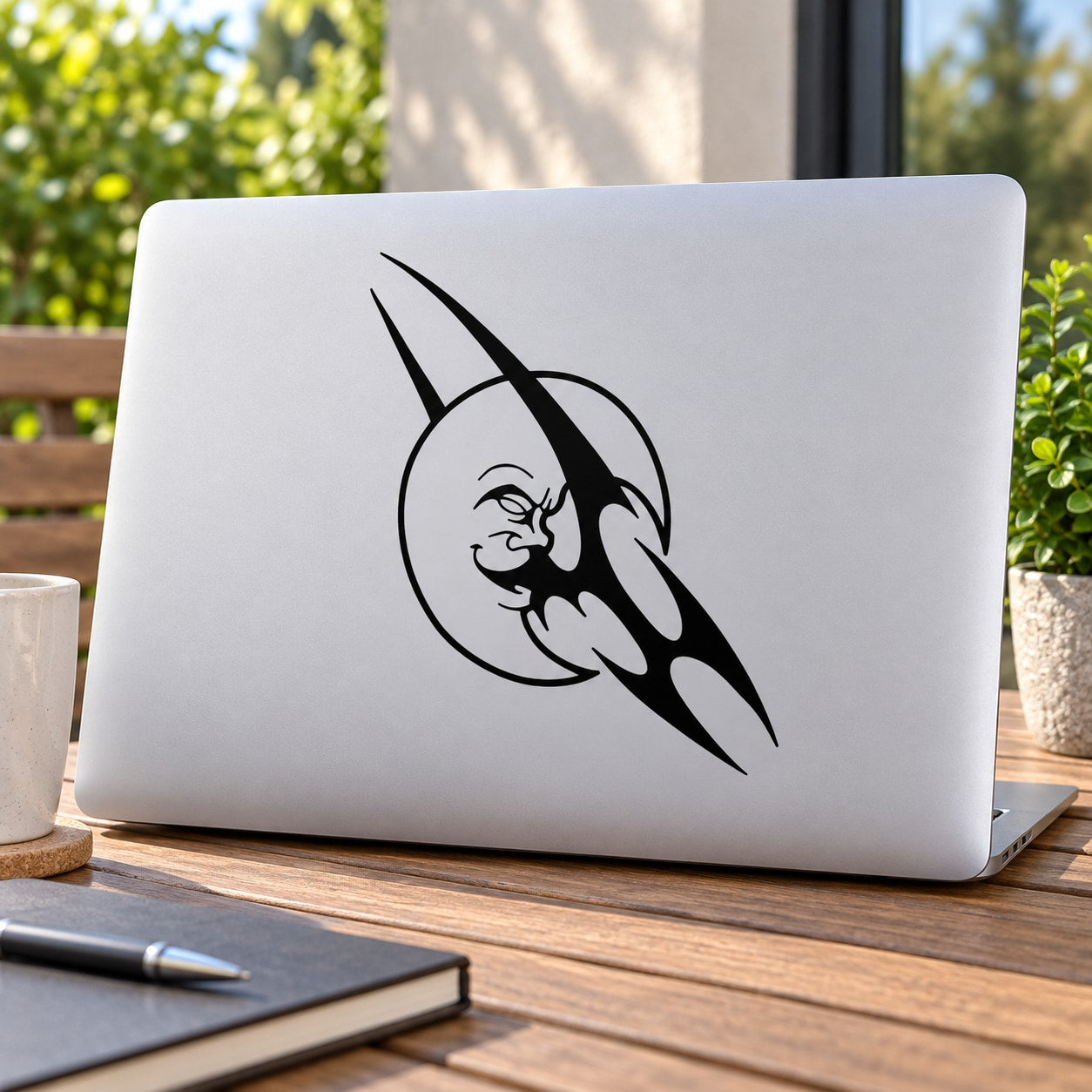 Tribal moon and cat face decal in black on a light laptop lid