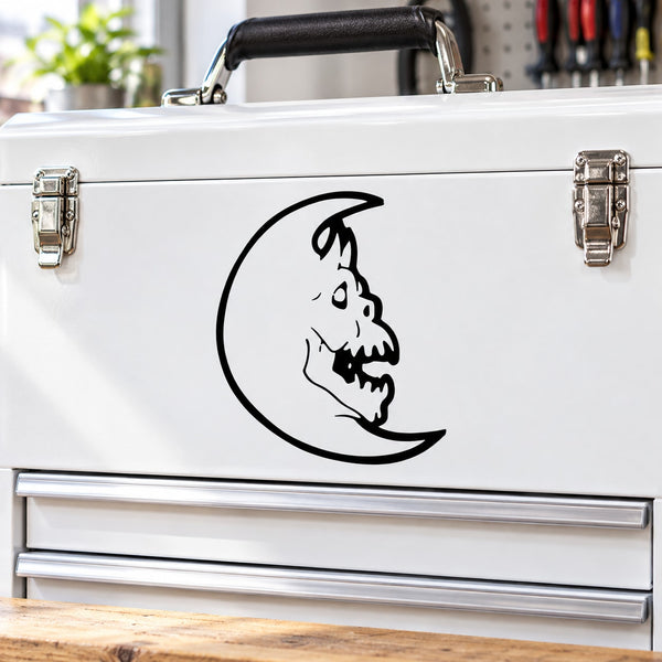 Moon creature decal with black face on crescent moon on a white surface