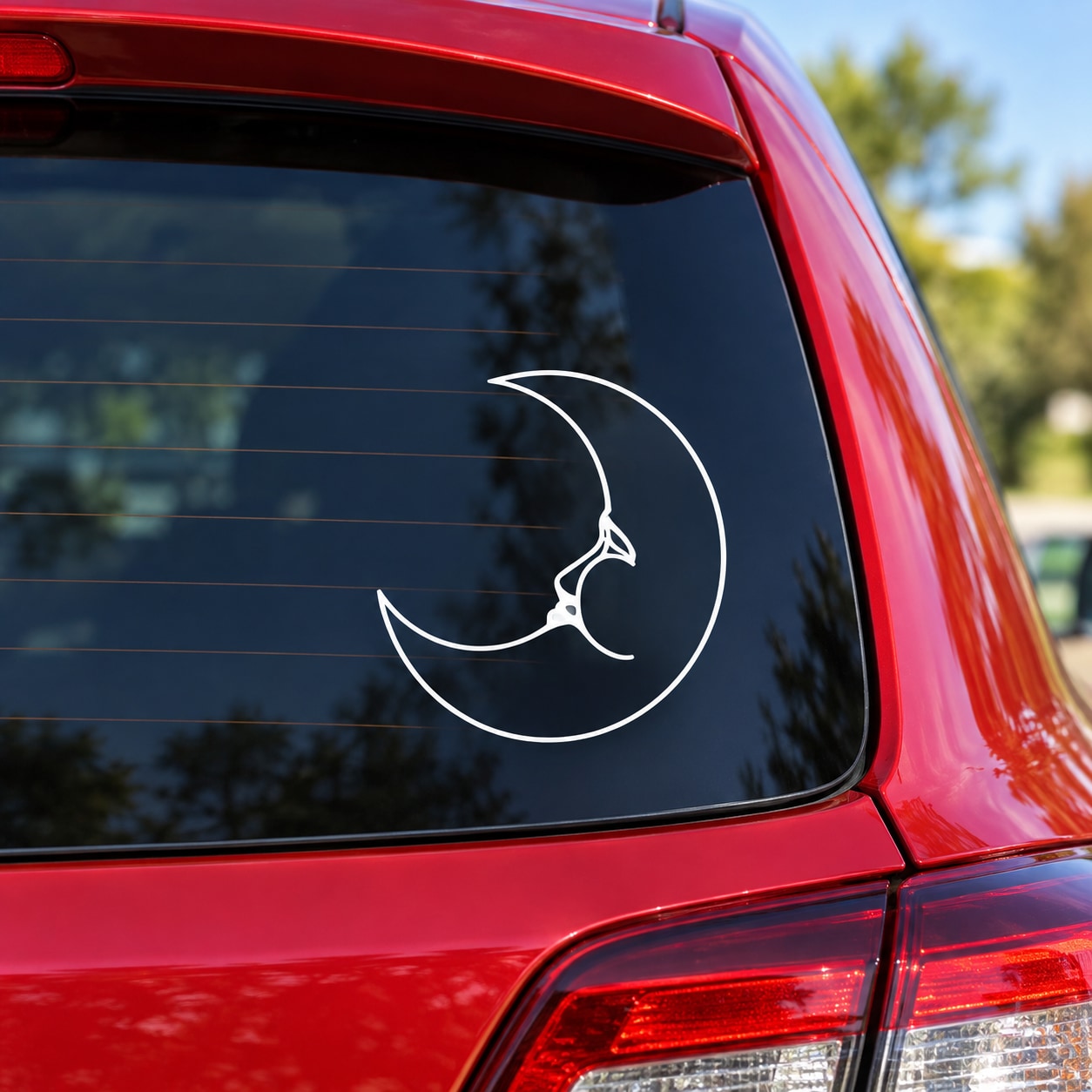 White moon-phase dreaming decal with crescent outline on car window
