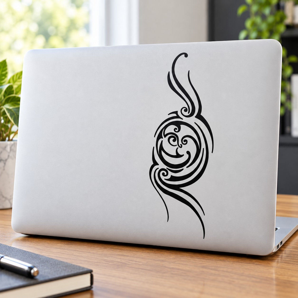 White laptop with black decorative full moon face line art graphic