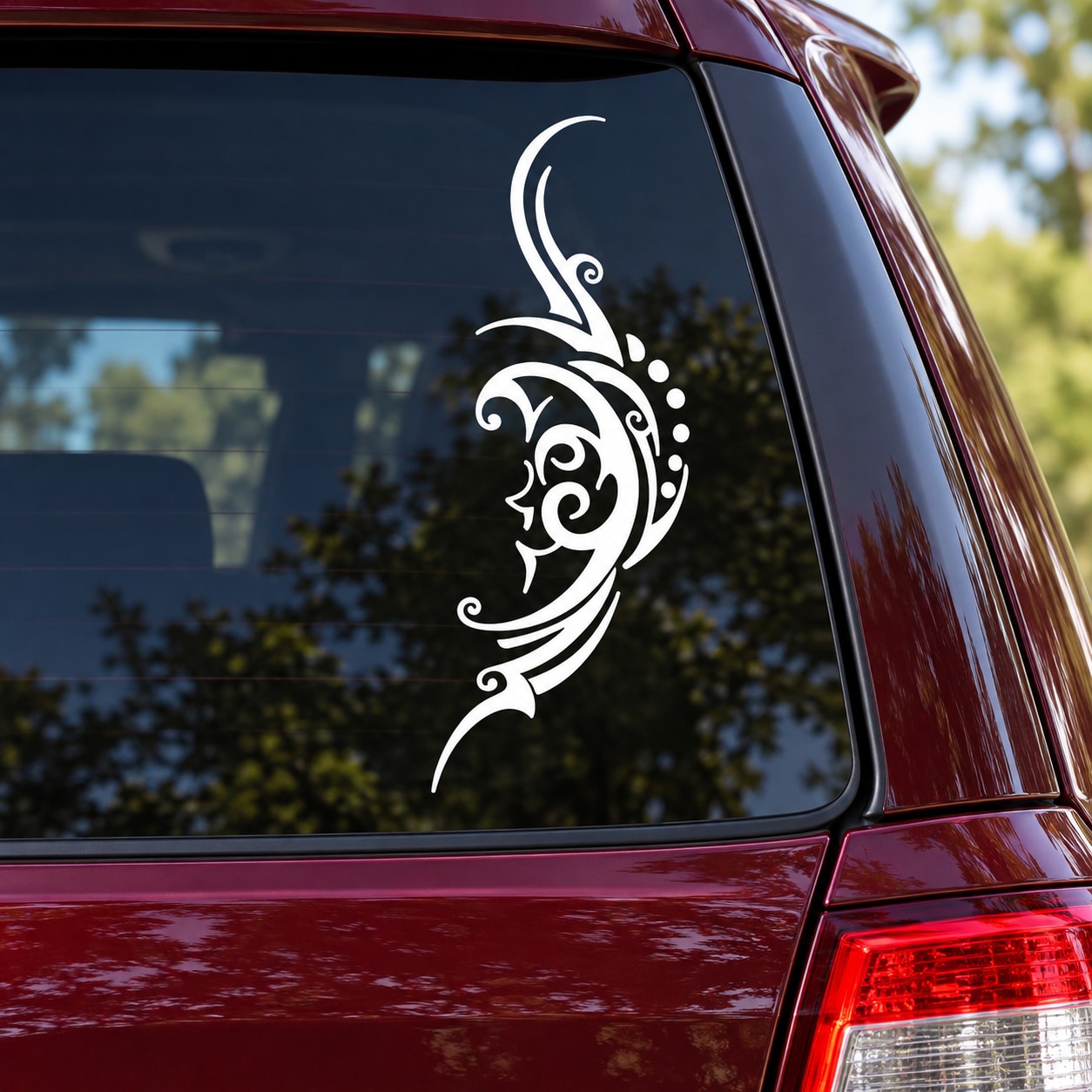 Tribal crescent moon face decal sticker, white decorative design on car window glass.