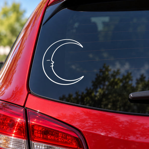 White crescent moon face vinyl decal on dark car window