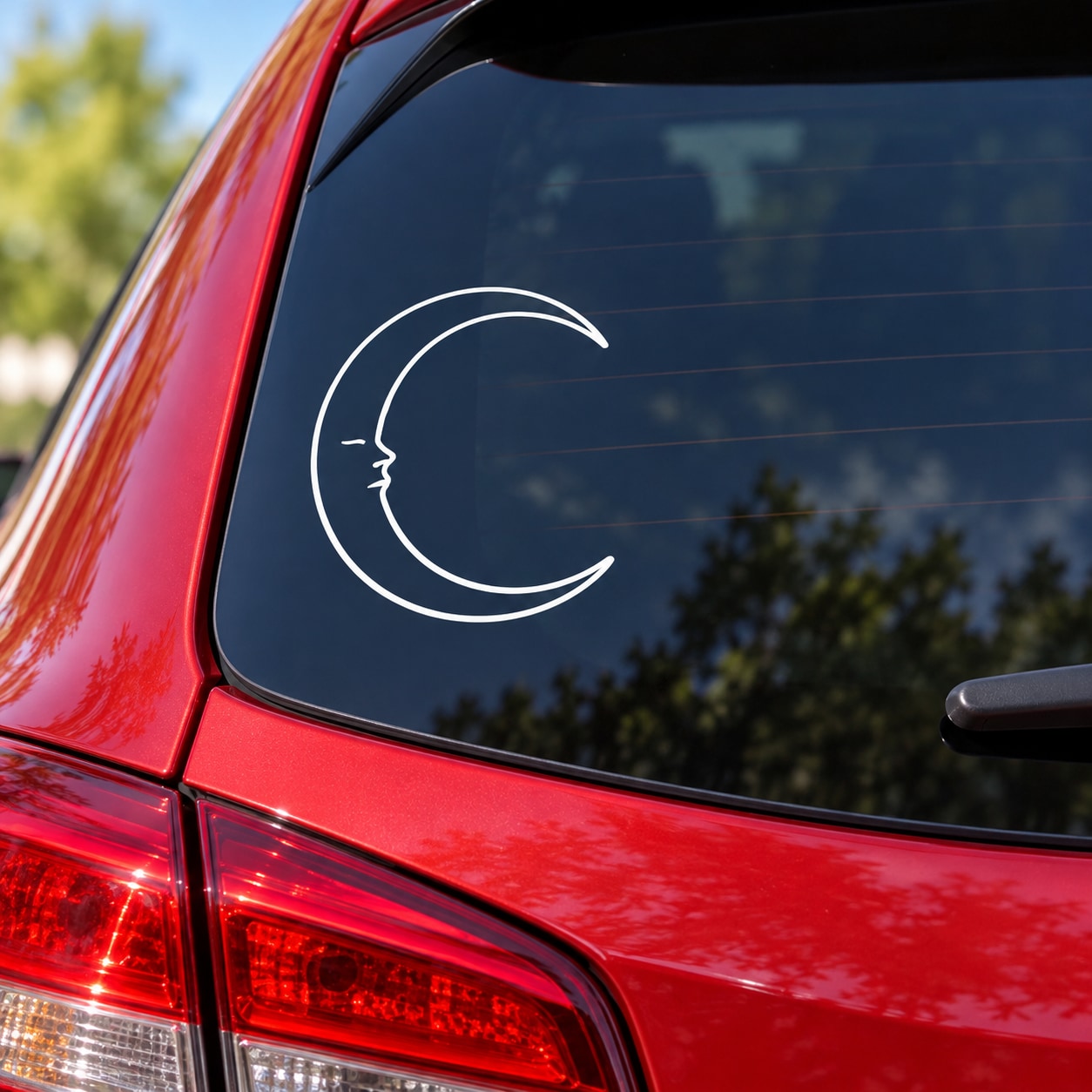 White crescent moon face vinyl decal on dark car window