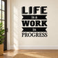 Black wall decal with stacked text: "LIFE is a WORK in PROGRESS"