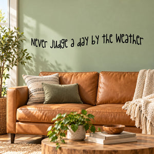 Wall decal text: "Never judge a day by the weather" in black script