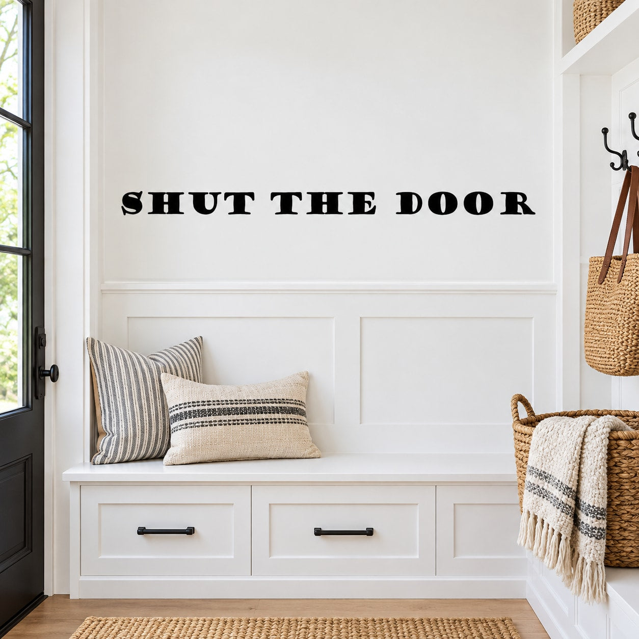 Wall decal reading "SHUT THE DOOR" in bold black letters on a light wall