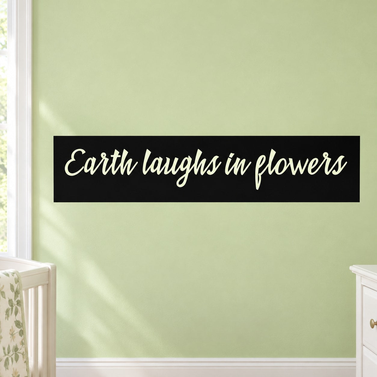 Wall decal with script text "Earth laughs in flowers"