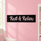 Wall decal with black rectangle and cursive “Rest & Relax” text