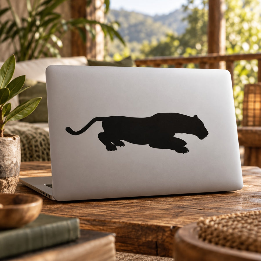 Panther pouncing decal, black silhouette on a light laptop lid