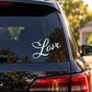 White cursive “Love” decal on car rear window