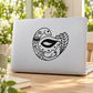 Art deco peacock decal: black line-art bird on light laptop lid