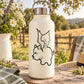 Flying pig outline decal on cream water bottle