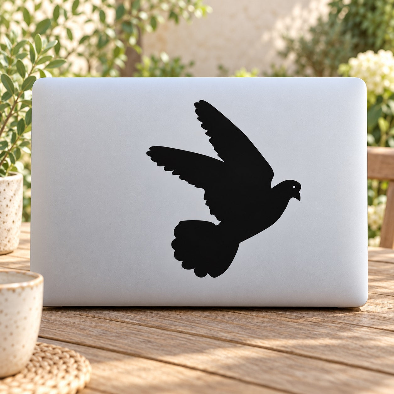 Flying pigeon decal with black pigeon silhouette, wings spread on smooth surface