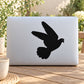 Flying pigeon decal with black pigeon silhouette, wings spread on smooth surface