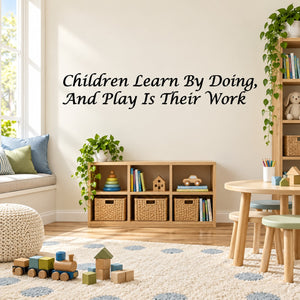Cursive wall decal reading “Children Learn By Doing, And Play Is Their Work”