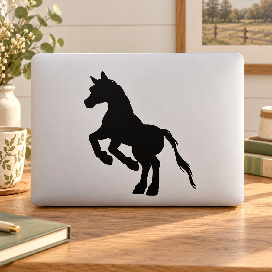 Jumping pony silhouette decal with black jumping horse design on white laptop