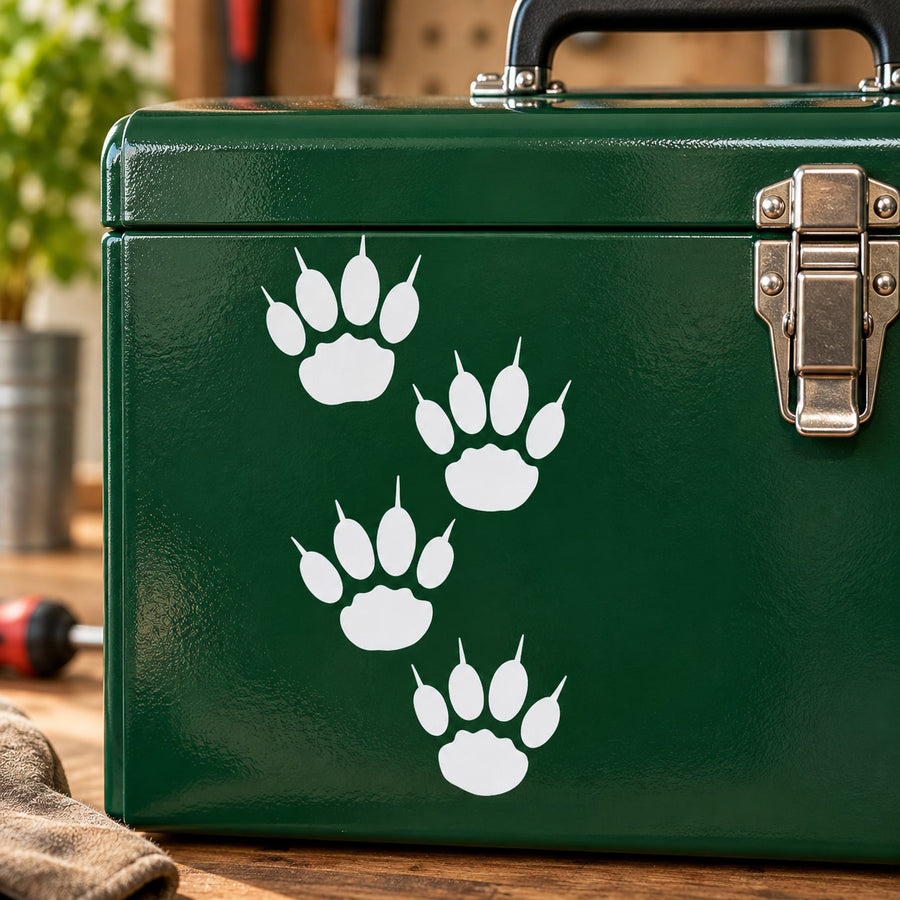 Lion track decal with four white paw print symbols on green surface