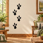 Black walking animal track decal with four paw prints on a wall