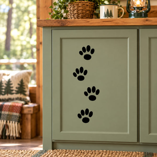 Walking cat track decal with four black paw prints on a light door panel