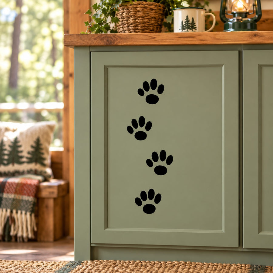 Walking cat track decal with four black paw prints on a light door panel