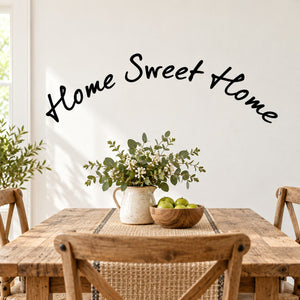 Curved wall decal with black “Home Sweet Home” script and small leafy floral cluster