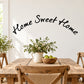 Curved wall decal with black “Home Sweet Home” script and small leafy floral cluster