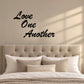 Stacked wall decal reading “Love One Another” in black script