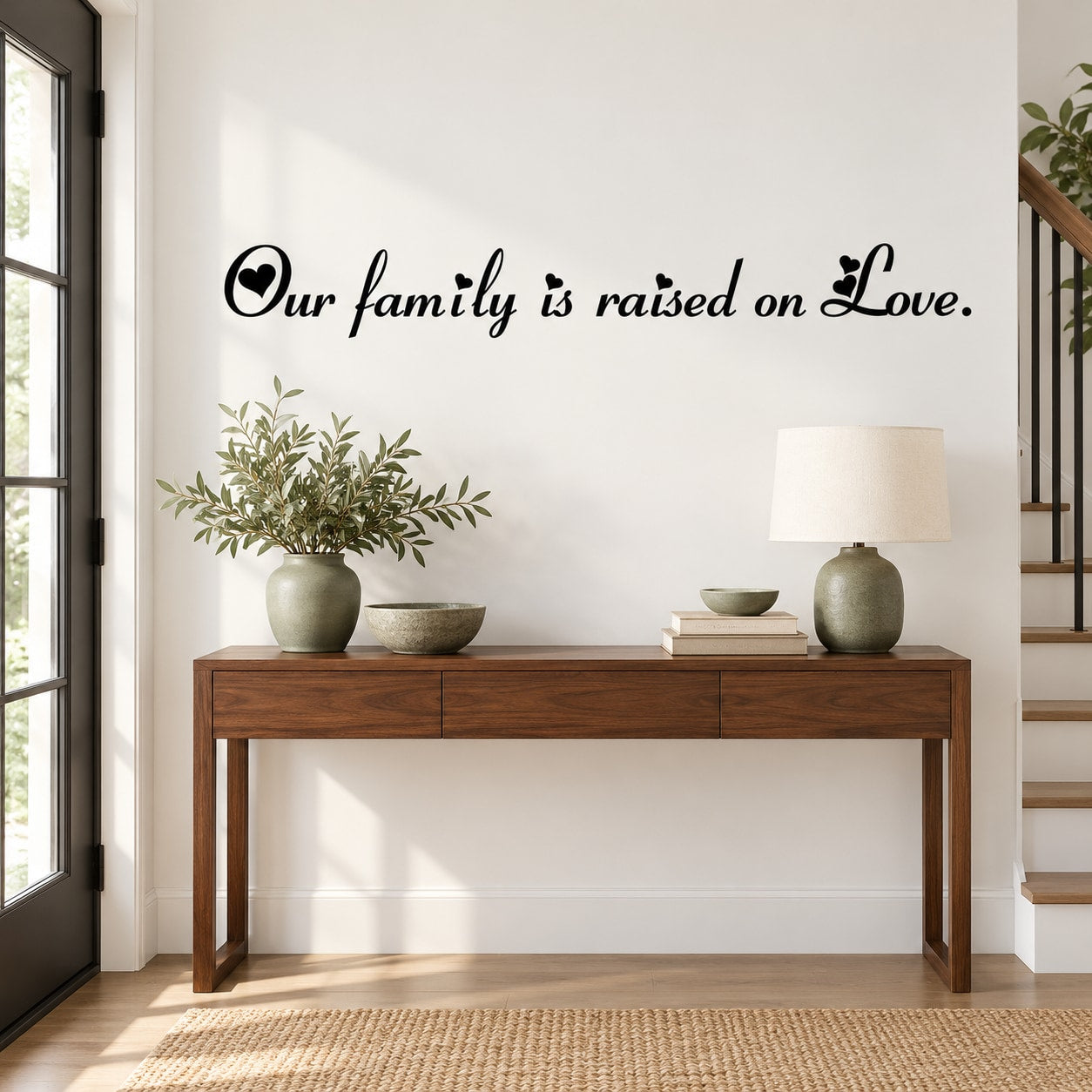 Wall decal with cursive text: "Our family is raised on Love." in black