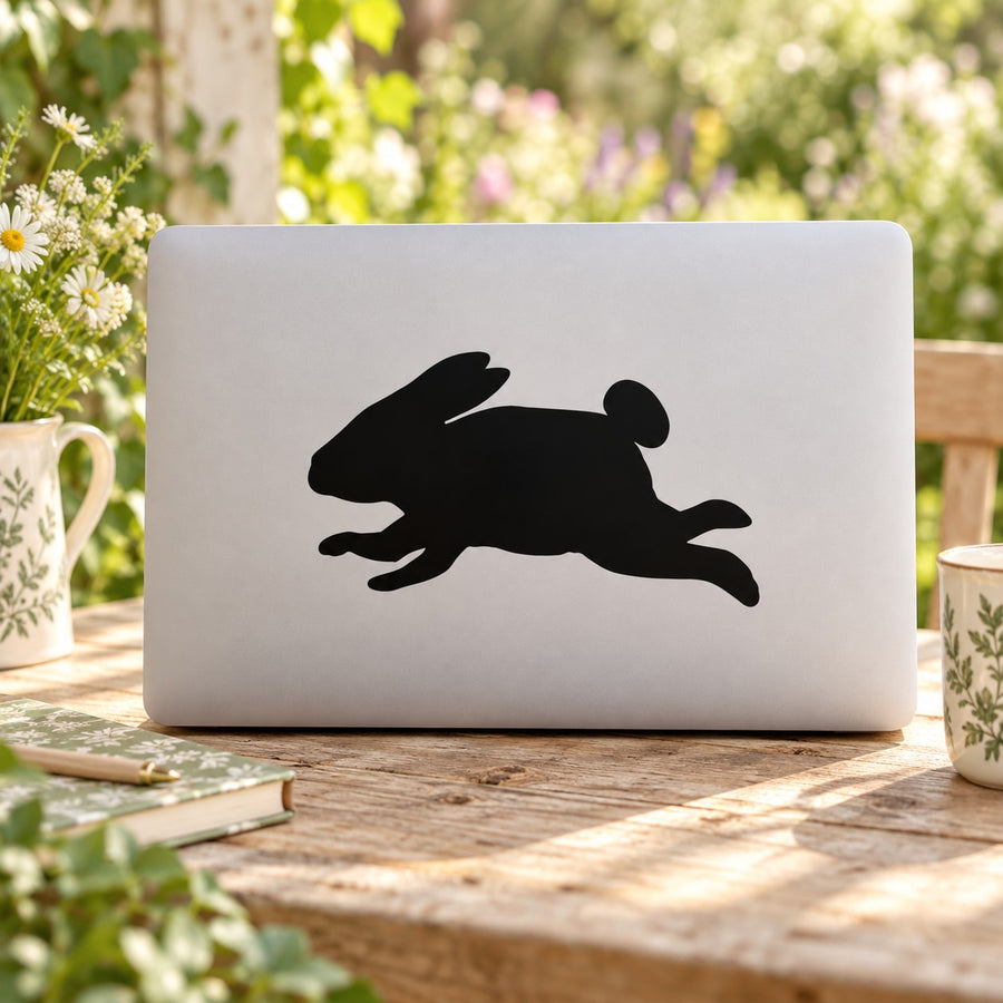 Leaping rabbit decal sticker with black jumping rabbit silhouette on light laptop lid